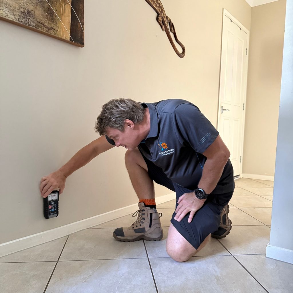 Building Inspector Using Moisture Meter"